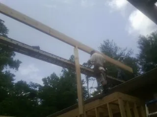 Carpenter setting a ridge beam over a new addition frame — Ice Dam Removal by Roofing Brothers in Calhoun